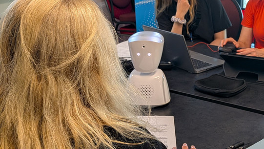Foto: kleiner Roboter bestehend aus Kopf und Körper in schlichtem weißem Design